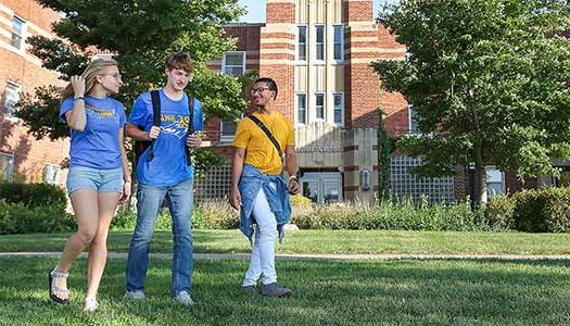 3 Students walking in front of Men's Hall